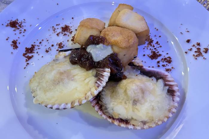 Zamburiñas rellenas con dados de mero llegaron en una salsa de inspiración balear, gratinadas con queso La Peral y acompañadas de polvo de pimientos de La Vera.