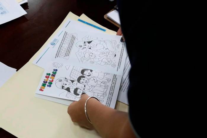 Los cuadernos y libros escolares incluyen caricaturas de la alcaldesa junto a mensajes educativos y comunitarios.
