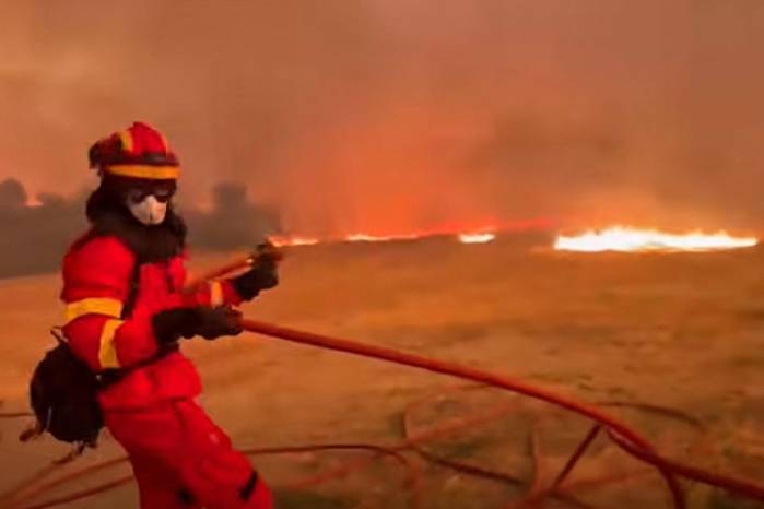 Esta captura de pantalla tomada de un video distribuido por la Unidad Militar de Emergencias de España el 16 de julio muestra a un integrante de esa unidad participando en las labores para combatir un gran incendio forestal en una zona escasamente poblada de la comunidad autónoma de Aragón.