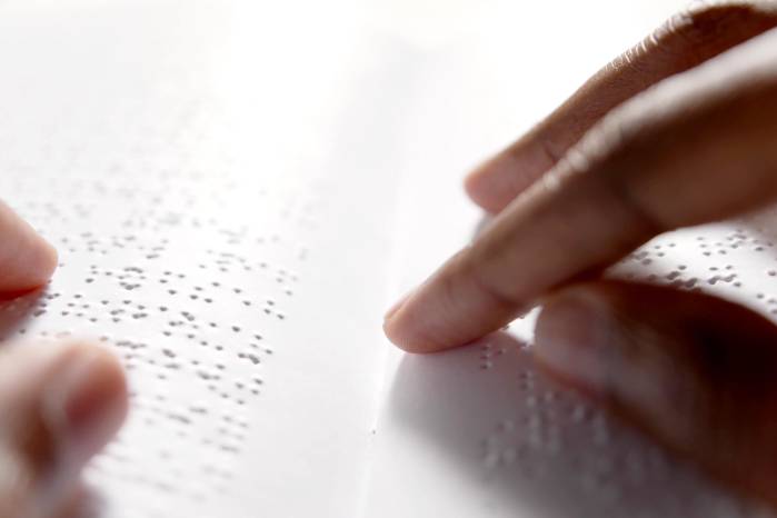 Black hands are reading braille