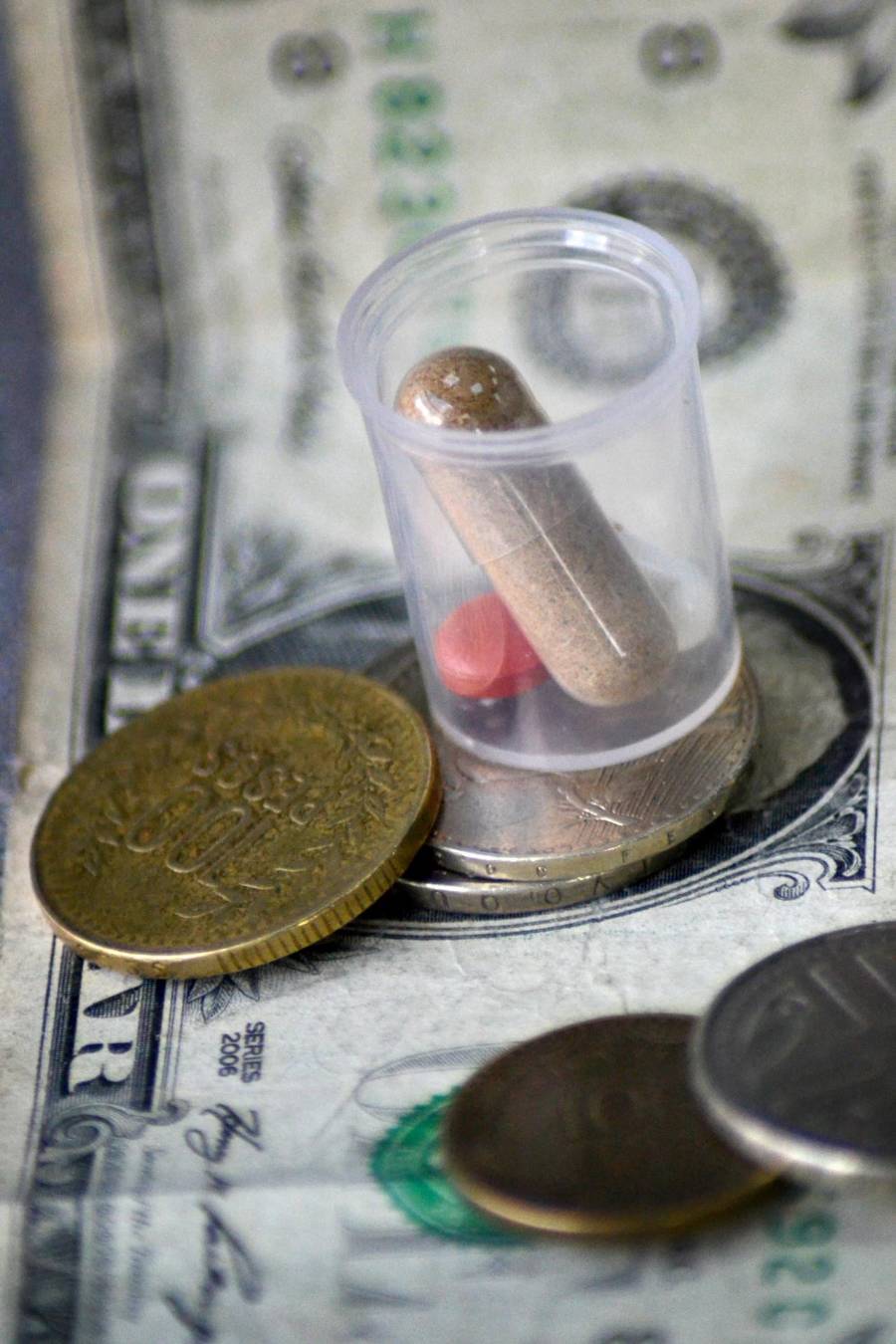 Fotografía de archivo que muestra medicamentos junto a un billete y monedas en Bogotá (Colombia).