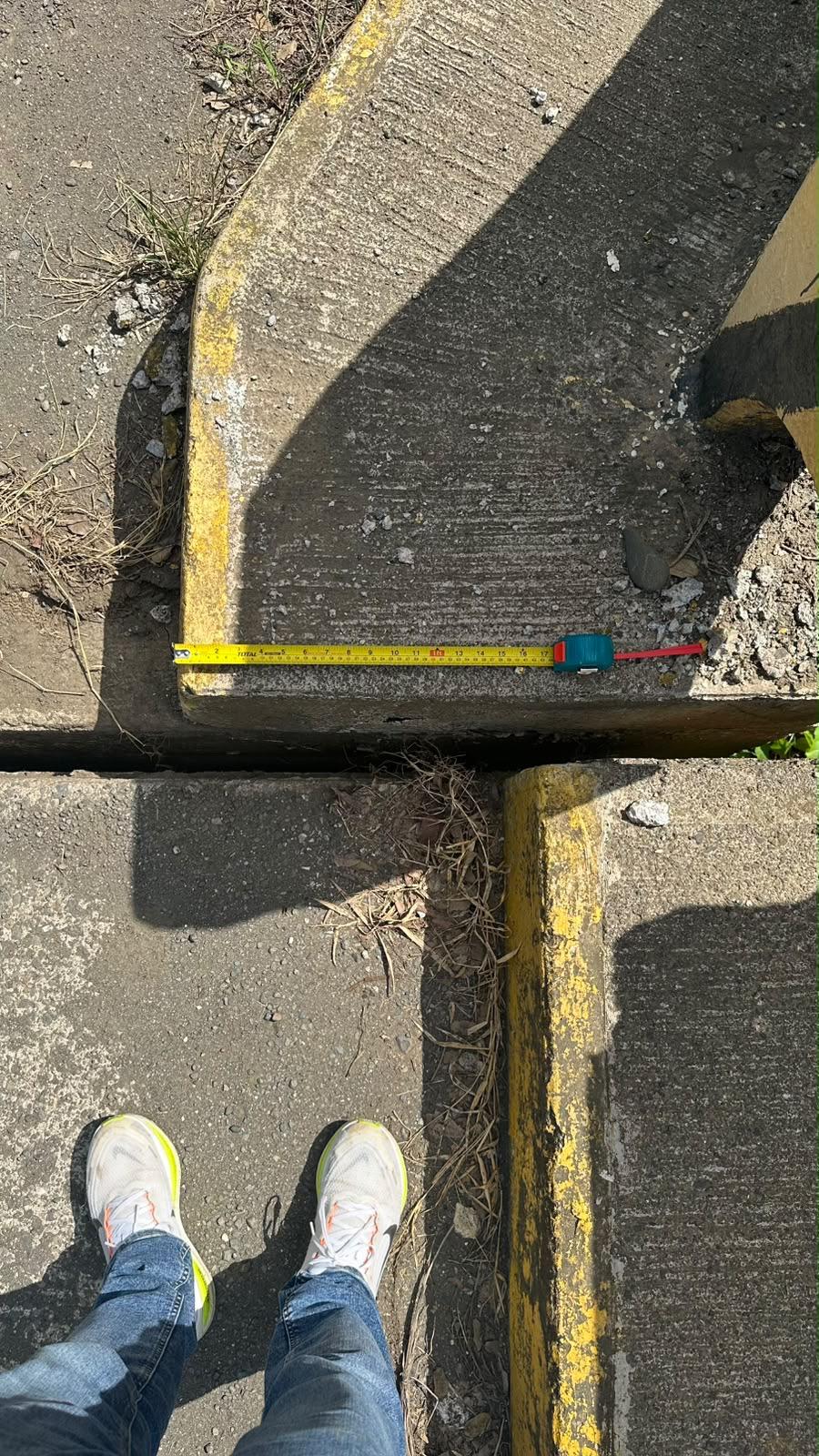 Evidencia de desplazamiento relativo entre segmentos de un puente (Puente de Tonosí) tras el terremoto. Se observa una desalineación lateral de los bordillos y una separación en la junta estructural, indicativas de una posible deformación asociada al movimiento sísmico. La cinta métrica se usa como referencia para documentar el desplazamiento observado en campo.