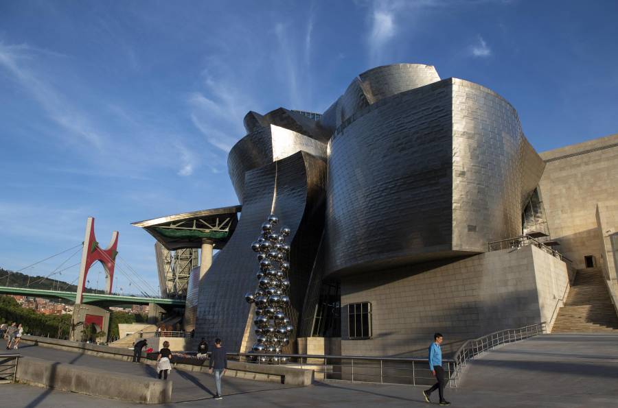 Vista general del Museo Guggenheim Bilbao, junto a la obra “Arku Gorriak” (Arcos Rojos) del francés Daniel Buren en el puente de La Salve (izq.) de Bilbao, en España.