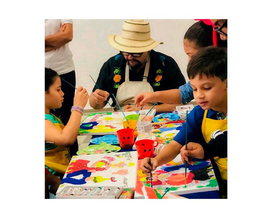 Rolo De Sedas impartiendo a jóvenes un taller de pintura.